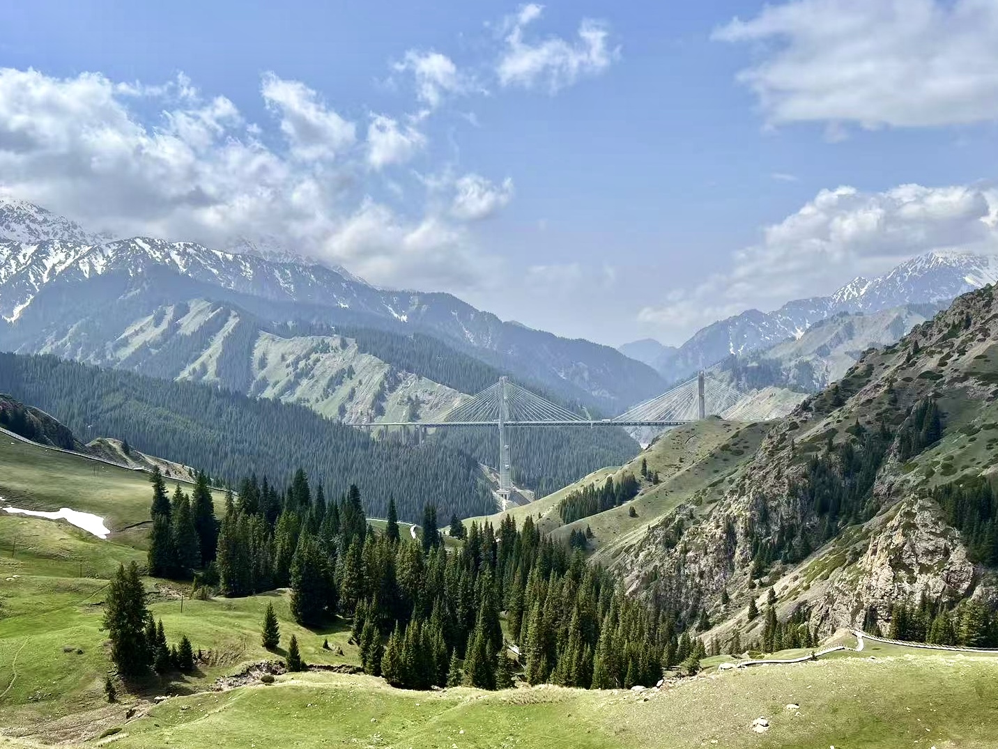 “五一”假期,新疆的果子沟大桥与雪山、草原交相辉映。受访者供图