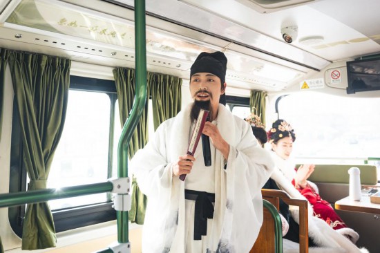 身着古装的“伴游”在“长安寻梦”主题观光车上为游客讲解。（受访者供图）